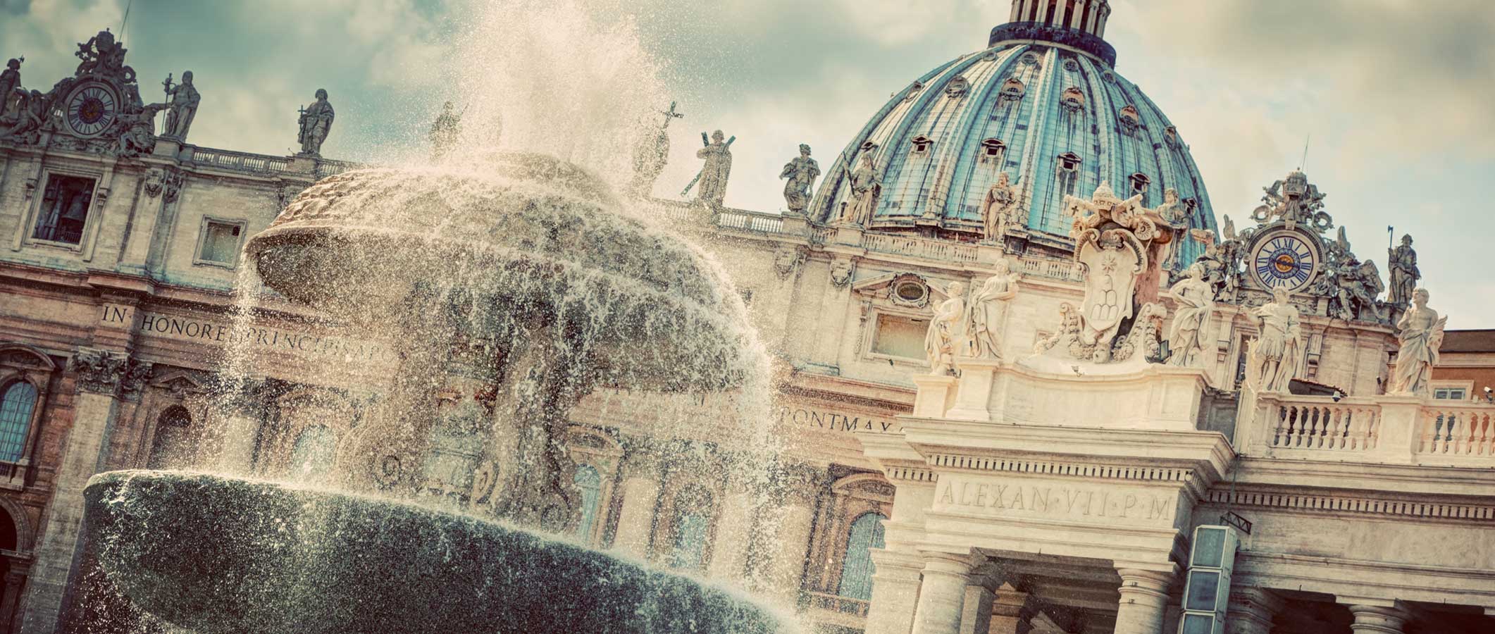 Photographie d'une fontaine d'eau devant la Cité du Vatican